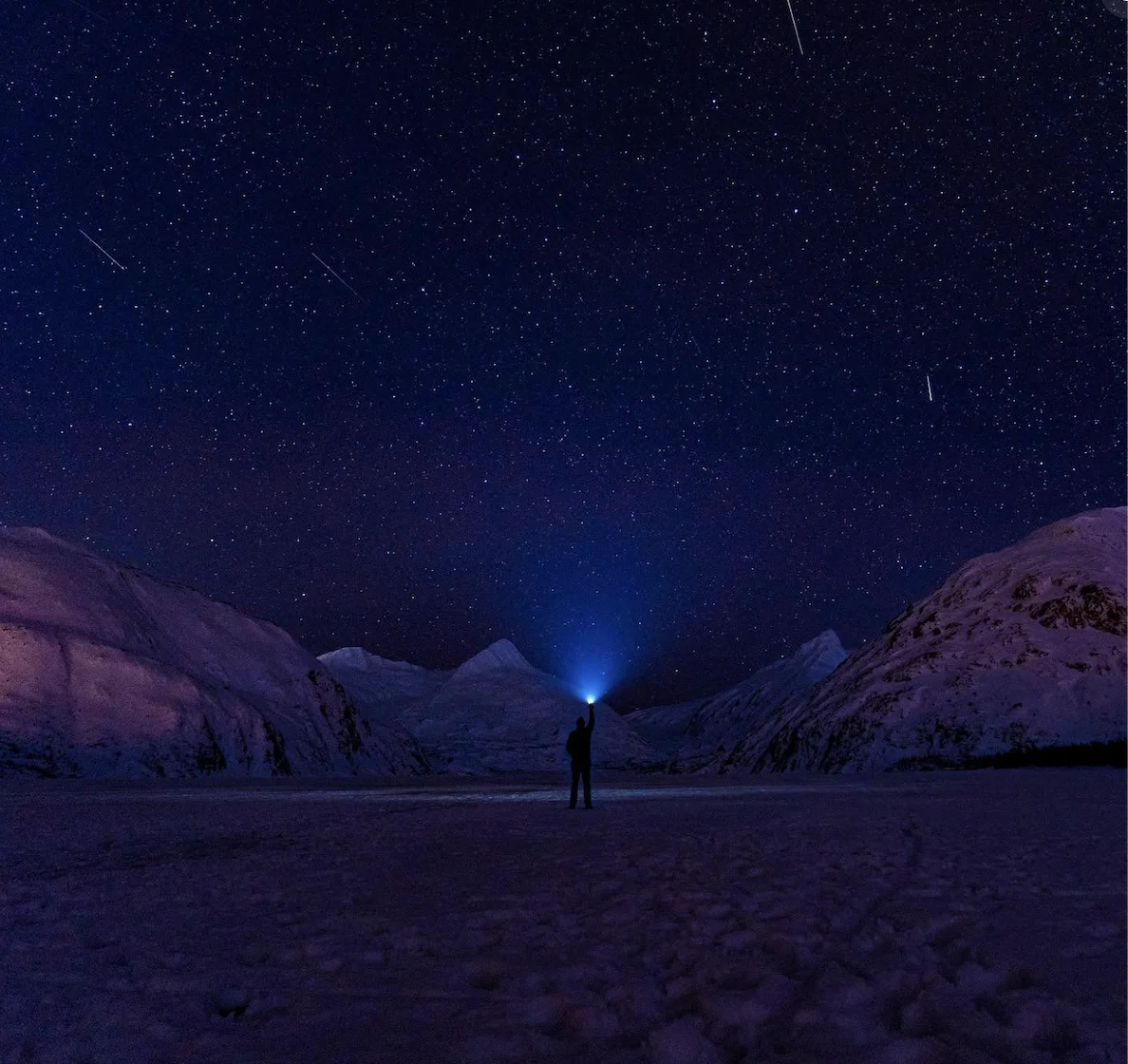 Night sky with a single spark of light over mountains, representing the spark of marketing clarity